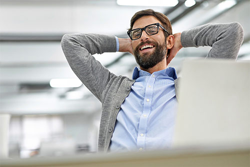 Man leaning back in his office chair looking happy