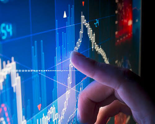 Finger pointing to a illuminated display of graphs and data