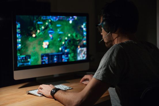 Man wearing a headset playing a computer game