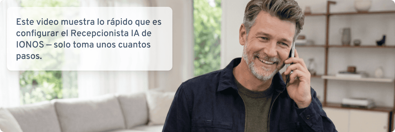 Un hombre sonriente habla por teléfono en una sala de estar.