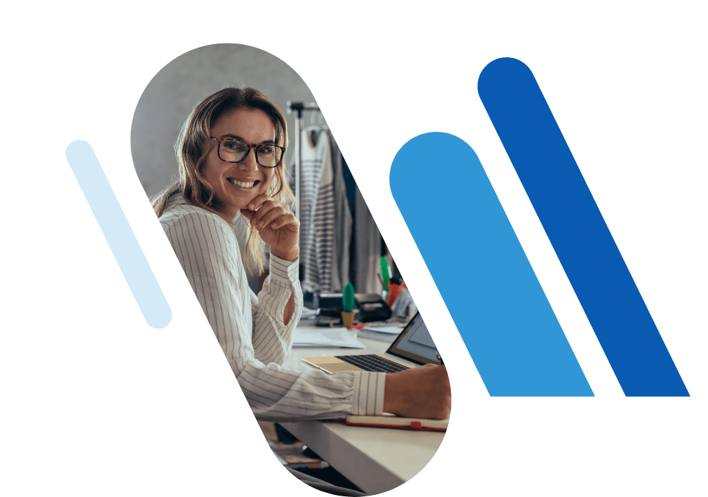 Smiling woman with glasses at desk, surrounded by blue bars in an office.